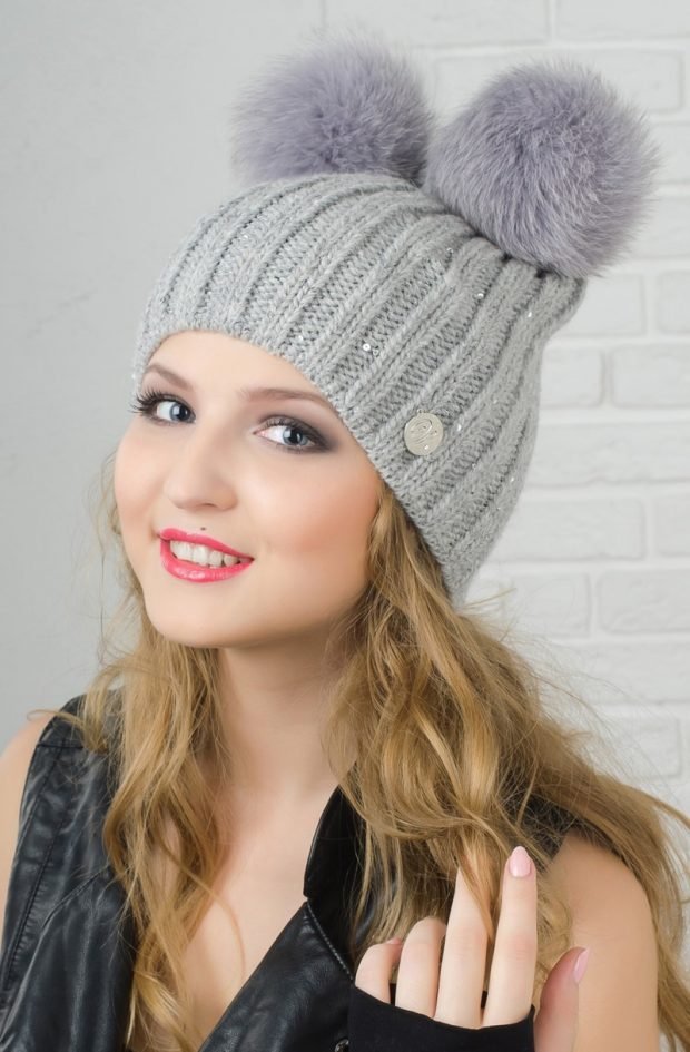 модные головные уборы осень зима 2020 2021: светло-серая вязанная шапка с двумя помпонами