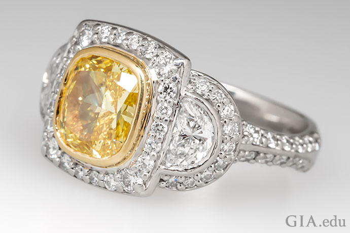 A 2.03 ct fancy vivid yellow diamond engagement ring set in platinum with an 18K gold bezel.