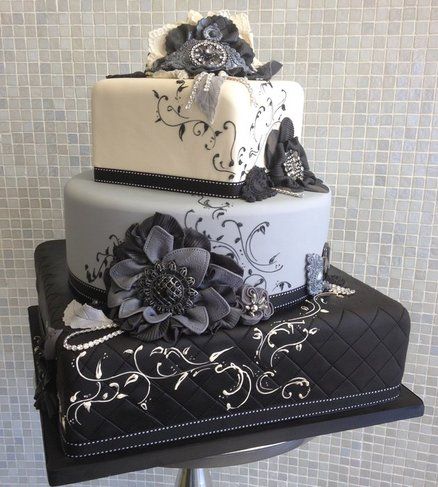 Play with the wedding cake geometry. Two square and one round tier in different shades of grey.