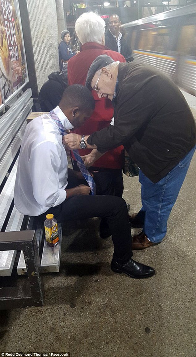 Helping hand: This heartwarming photograph of an elderly man showing a young man how to tie his tie at a subway station in Atlanta has gone viral, after being posted on Facebook yesterday