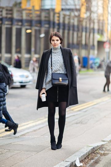 Девушка в короткой, черной юбке, свитере и пальто