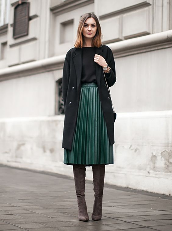 зеленая плиссированная юбка-миди, черный топ, черное пальто и коричневые замшевые ботинки