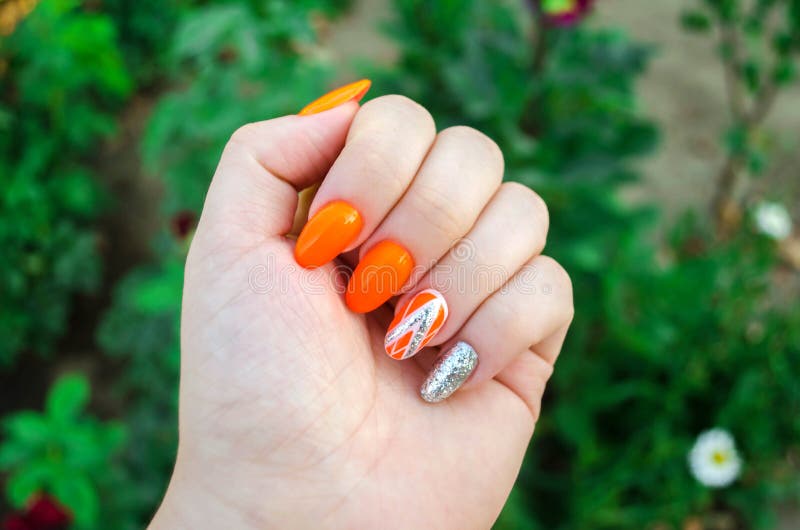 Perfect manicure and natural nails. Attractive modern nail art design. orange autumn design. long well-groomed nails.  stock photo